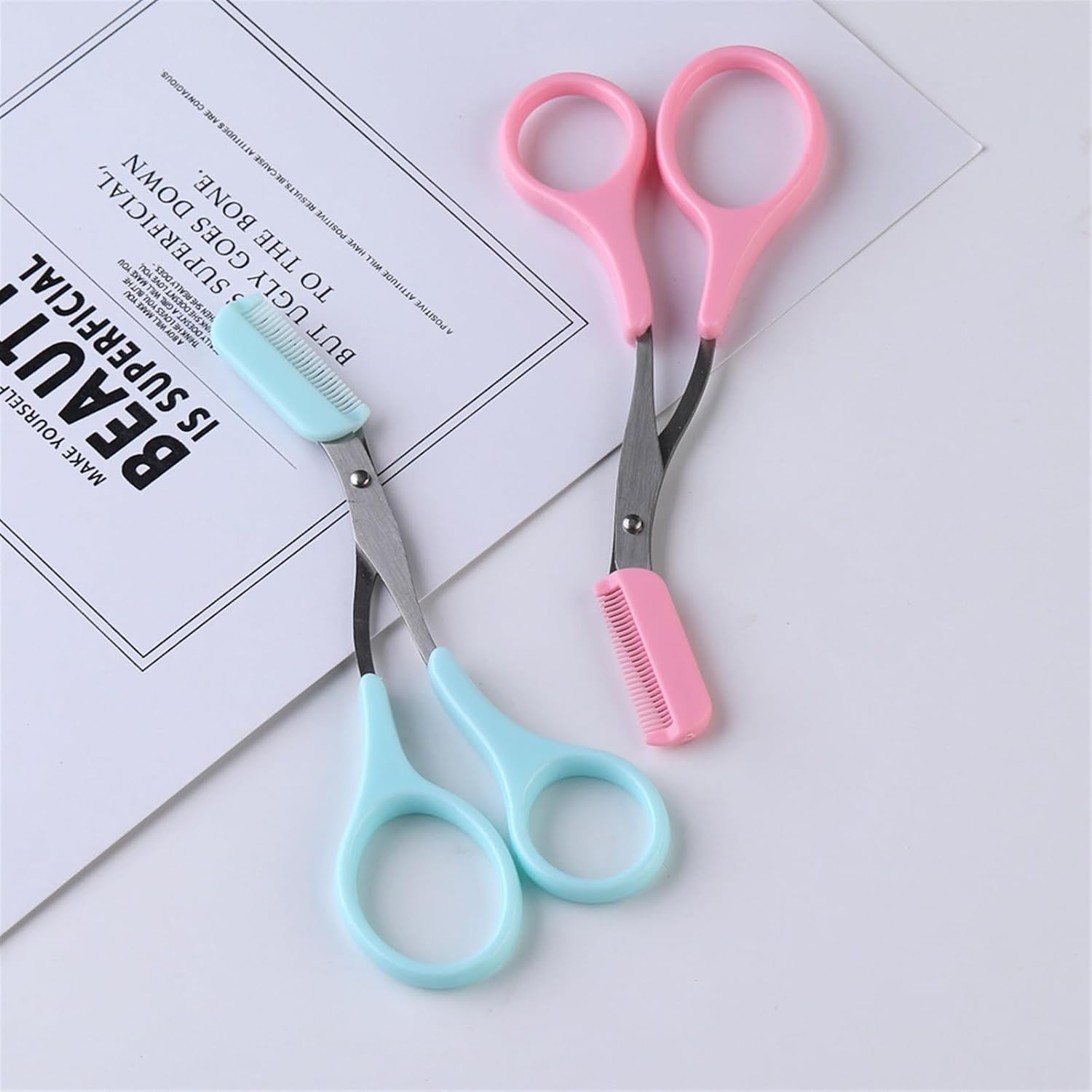 Two pairs of scissors with pink and blue handles on a white background