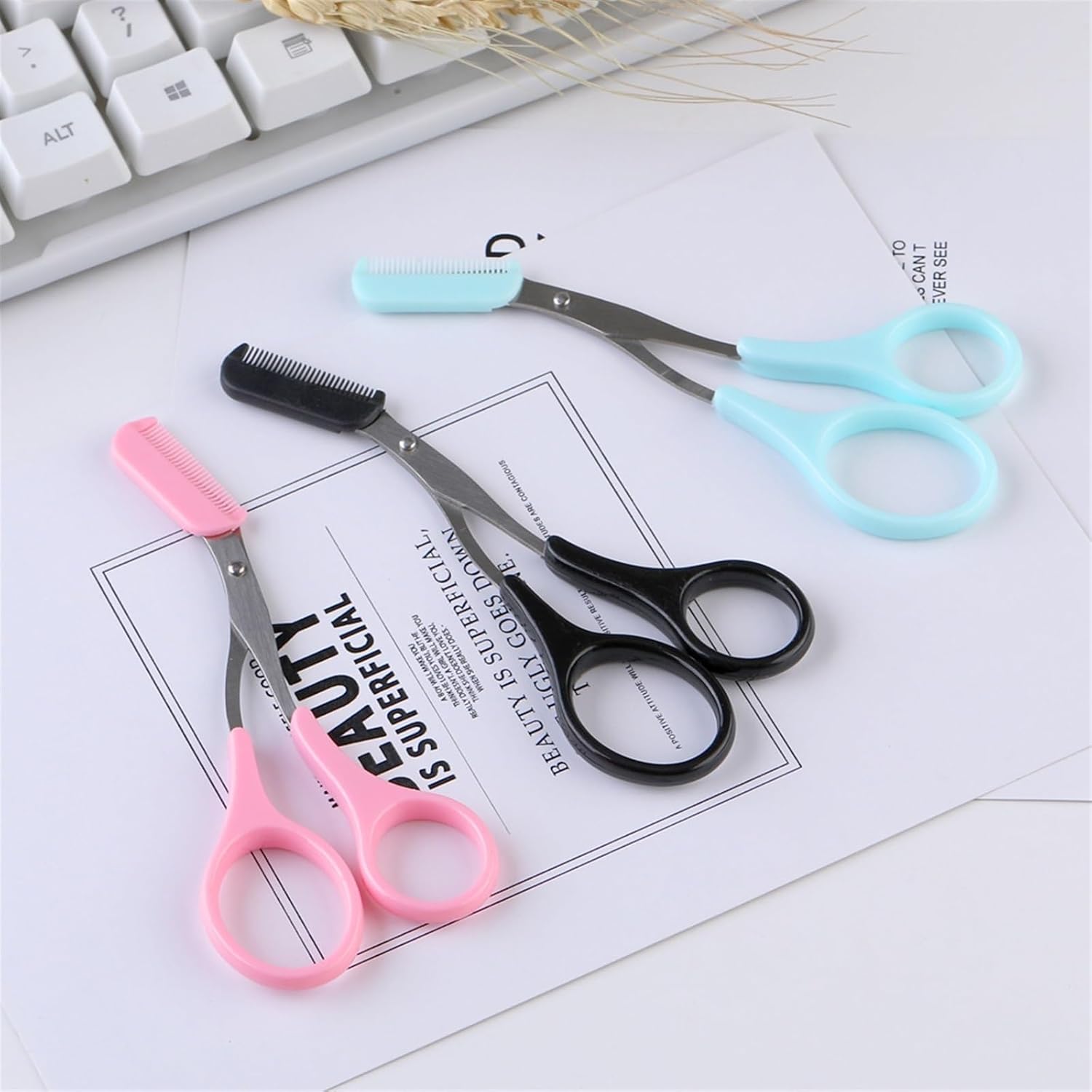 Set of small scissors with colorful handles on a white surface.